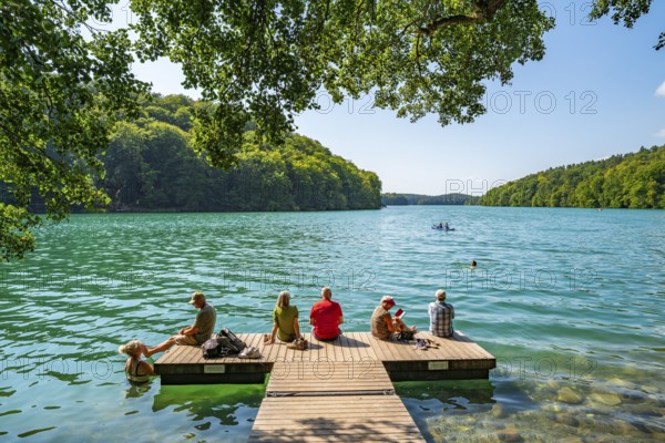 People on a boat dock and in turquoise blue water, Schmaler Luzin Lake, Feldberg Lake District, Mecklenburg Lake District, Mecklenburg-Western Pomerania, Germany