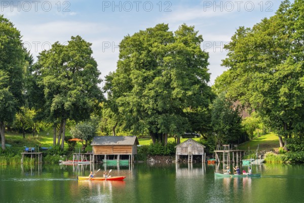 Carwitz Lake with paddlers and boathouses, Feldberger Seenlandschaft, Mecklenburg Lake District, Mecklenburg-Western Pomerania, Germany