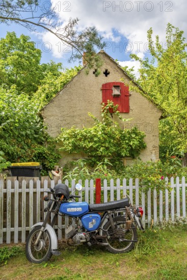 Blue motorcycle from the GDR brand Simson stands in front of an old house, village of Carwitz, Feldberger Seenlandschaft, Mecklenburg Lake District, Mecklenburg-Western Pomerania, Germany