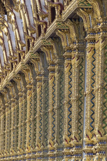 Columns with mosaic decorations (Lai Kranok), also: golden, mosaic-decorated Thai temple columns (Sao), decorated in the Lai Kranok style, typical of Rattanakosin architecture (Bangkok style), on the outer faÃ§ade of the Ubosot (ordination hall), Wat Chana Songkhram, Phra Nakhon, Bangkok, Thailand