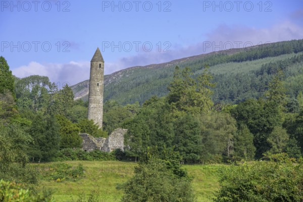 Round tower surrounded by forest, Glendalough, Wicklow Mountains National Park, Brockagh, County Wicklow, Ireland