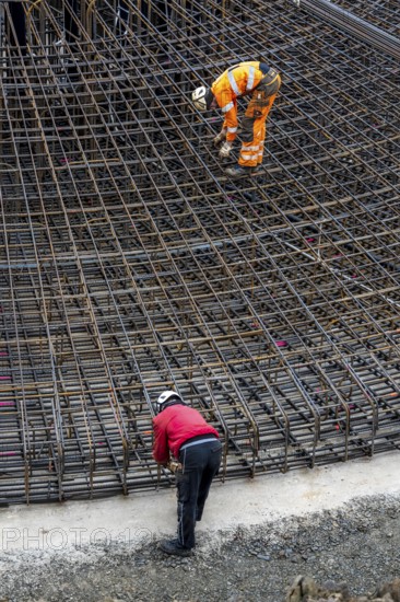 Assembly of reinforcing steel for the reinforced concrete foundation of a wind turbine, a mesh of rebar and reinforcing steel mesh, connecting the steel elements with binding wire, twisting with tongs, over 100 tons of reinforcing steel were used, the wind turbine will have a hub height of 160 meters, part of a new wind farm in Sauerland, near Balve, North Rhine-Westphalia, Germany