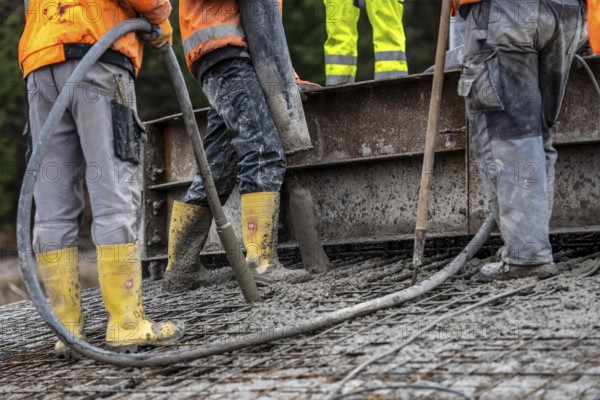 Concreting, concreting the foundation of a wind turbine, concrete pump hose, compressor, more than 600 cubic meters of concrete will be pumped into the foundation for over 7 hours, over 100 tons of reinforcing steel have been used, the wind turbine will have a hub height of 160 meters, part of a new wind farm in Sauerland, near Balve, North Rhine-Westphalia, Germany