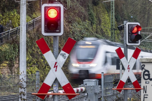 Rail crossing with regional train at Bad Wimpfen station. Flashing light, St. Andrew's Cross and barrier. Bad Wimpfen, Baden-WÃ¼rttemberg, Germany