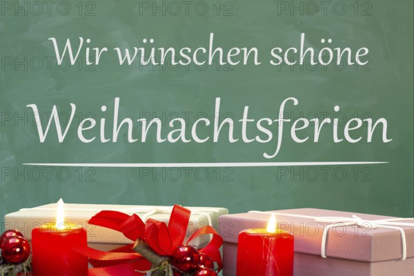(Photo montage) Christmas decoration on a school blackboard with the inscription WE WISH YOU HAPPY CHRISTMAS HOLIDAYS