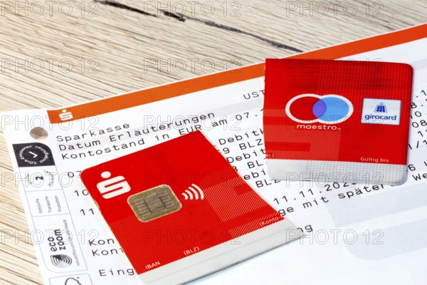 Cut-up savings bank card on account statements (symbolic image)