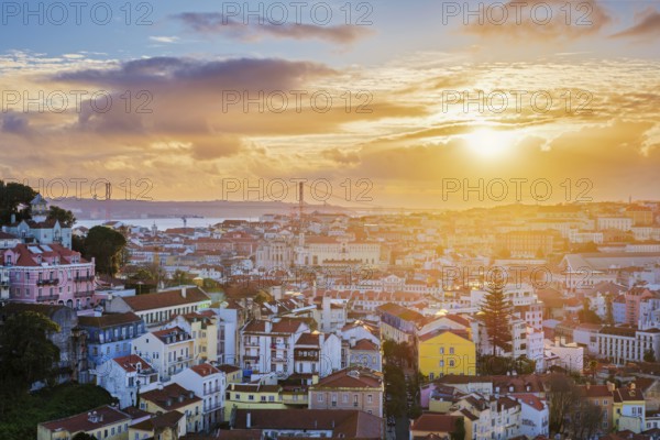 View of Lisbon famous view from Miradouro da Senhora do Monte tourist viewpoint of Carmo Convent Ruins and 25th of April Bridge on sunset. Lisbon, Portugal