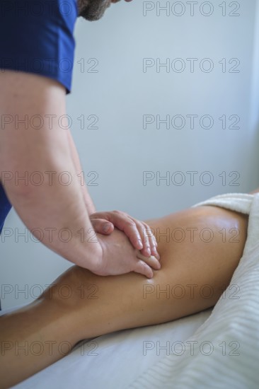 A skilled therapist performs a soothing leg and thigh massage using oil, promoting relaxation and wellness in a tranquil spa setting