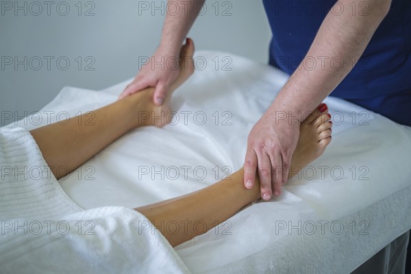 A woman enjoys a soothing calf massage at a spa salon, enhancing her wellness with a skilled therapist's touch