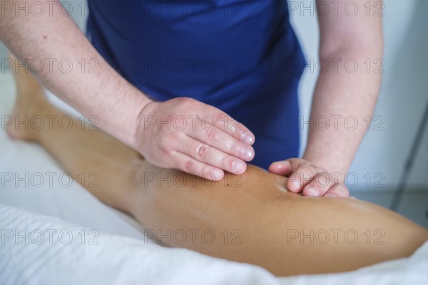 In a serene spa salon, a skilled therapist gives a soothing leg massage with oil, promoting relaxation and lymphatic drainage