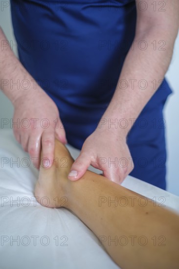 A woman enjoys a soothing foot and leg massage at a spa, where an expert therapist uses oil for relaxation and lymphatic drainage