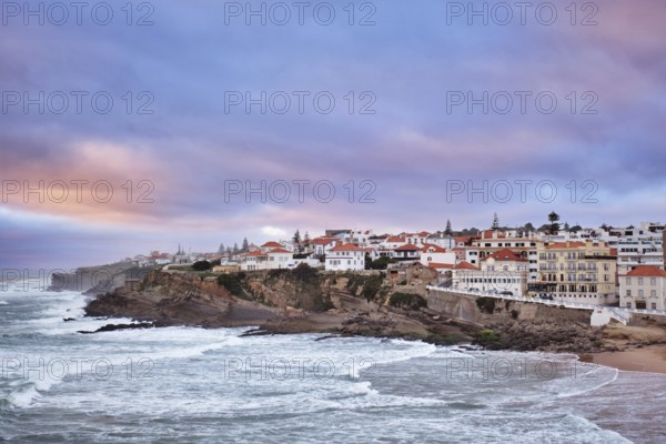 Beautiful sunset at Praia das Macas beach in Portugal. The village overlooks the ocean with colorful skies, creating a picturesque scene of natural beauty and serenity
