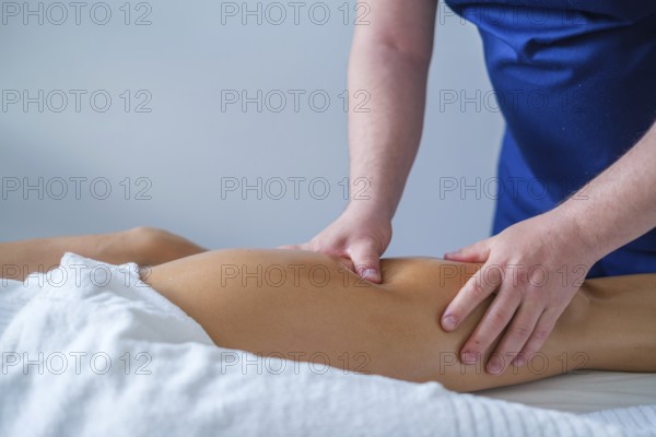 A therapist performs a soothing leg and thigh massage with oil in a spa salon. The focus is on relaxation and wellness care