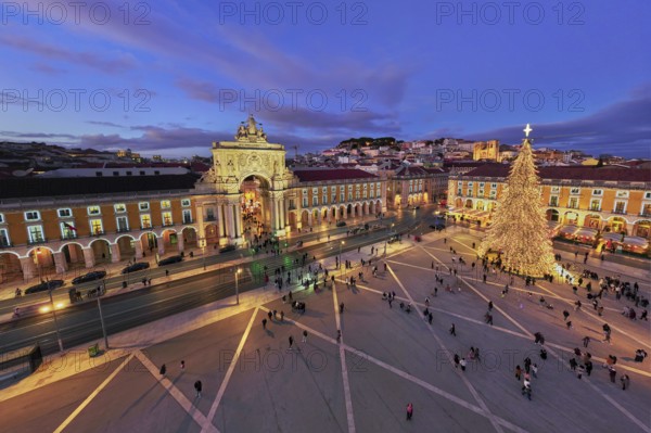 Praca do Comercio in Lisbon features a large Christmas tree and festive lights during evening twilight in winter. Lisbon, Portugal