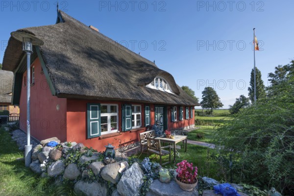 Private house with thatched roof, in front of a captain figure on a bench, Ahrenshoop, DarÃŸ, Mecklenburg-Western Pomerania, Germany