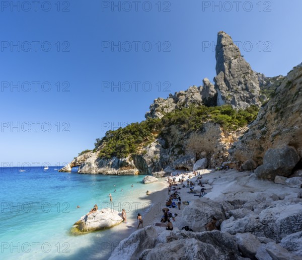 Light blue clear sea on a dream beach on Cala GoloritzÃ©, picturesque rocky coast, steep coast with rock pin L'Aguglia, Golfo di Orosei, Baunei, Sardinia, Italy