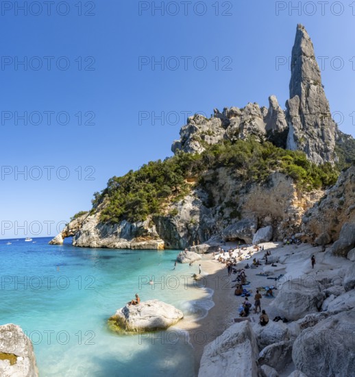 Light blue clear sea on a dream beach on Cala GoloritzÃ©, picturesque rocky coast, steep coast with rock pin L'Aguglia, Golfo di Orosei, Baunei, Sardinia, Italy