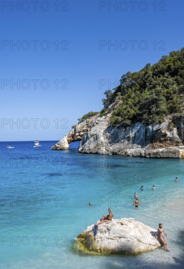 Light blue clear sea on a dream beach on Cala GoloritzÃ©, picturesque rocky coast, cliffs with rock arch, Golfo di Orosei, Baunei, Sardinia, Italy