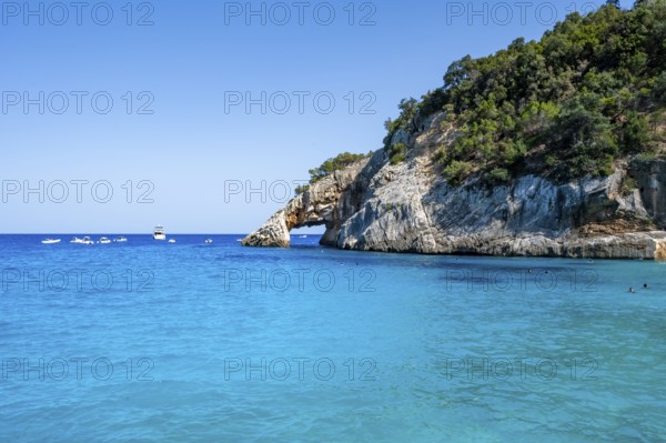 Light blue clear sea on a dream beach on Cala GoloritzÃ©, picturesque rocky coast with rock tunnel, cliffs, Golfo di Orosei, Baunei, Sardinia, Italy