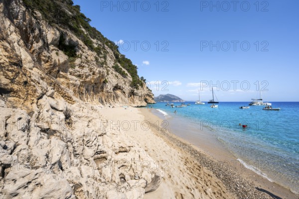 Sandy beach beach and steep cliffs at Cala Luna, Golfo di Orosei, Baunei, Sardinia, Italy