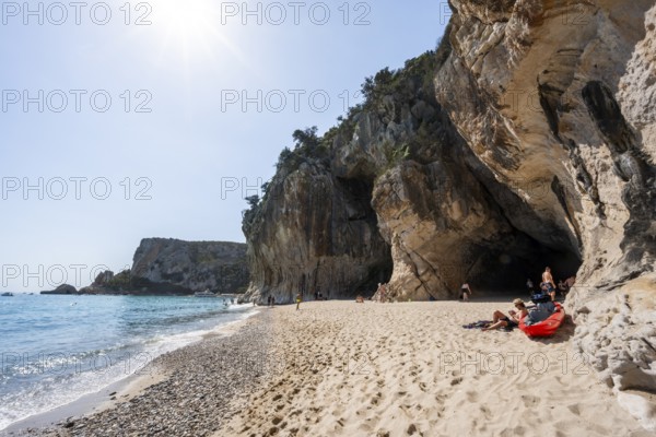 Sandy beach beach and steep cliffs with caves at Cala Luna, Golfo di Orosei, Baunei, Sardinia, Italy