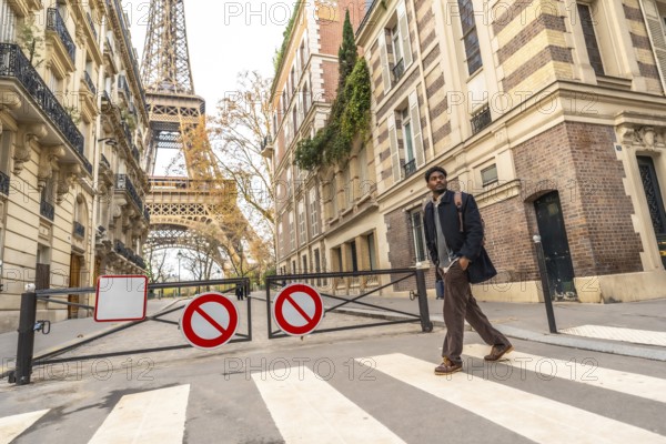 Young man crossing a street in paris, walking towards the iconic eiffel tower, embodying city travel, urban adventure, and exploring european landmarks