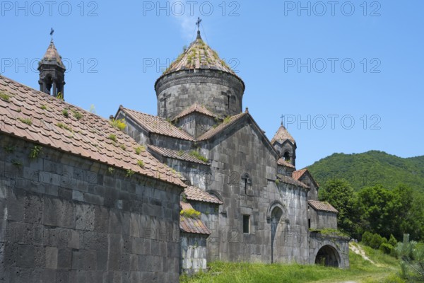Old monastery building with stone structures and dome in front of a green mountain landscape, Haghpat monastery, Haghpatavank, town of Haghpat, UNESCO World Heritage Site, Lorikeet province, Armenia