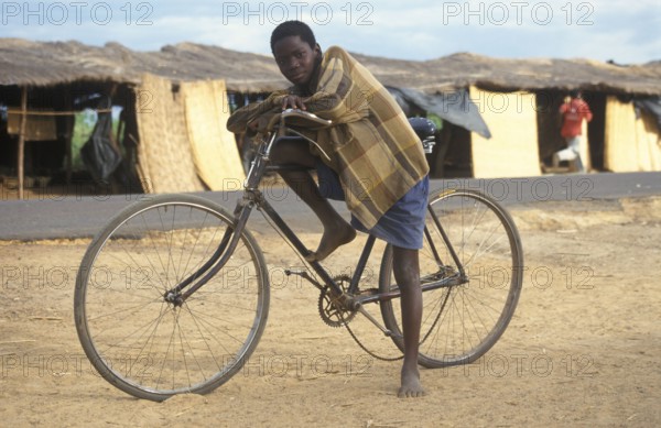 Boy with bicycle in front of a street market, Salima, Malawi, Africa, June 2000, vintage, retro, old, historic