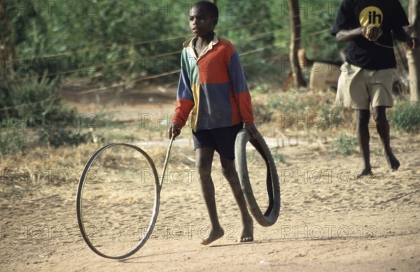 Boy playing with tires, Salima, Malawi, Africa, June 2000, vintage, retro, old, historical