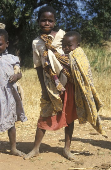 Girl carrying a toddler, Bwangu Mzimba, Malawi, Africa, June 2000, vintage, retro, old, historic