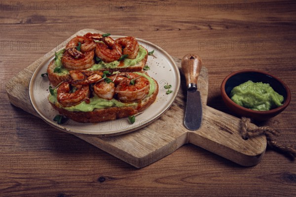Sandwiches with avocado and caramelized shrimp, micro-greens, breakfast, on a plate, top view, homemade, no people