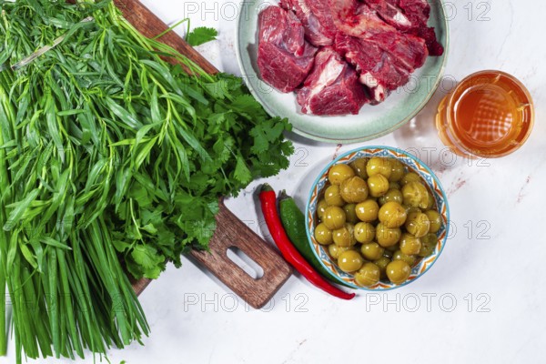 Ingredients for cooking chakapuli, canned tkemali, meat, herbs Georgian cuisine, top view