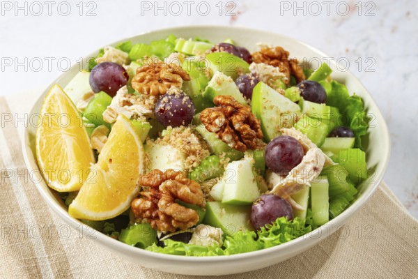 Fresh Waldorf salad, celery stalk with chicken, apple and walnuts, grapes, herbs, homemade, without people