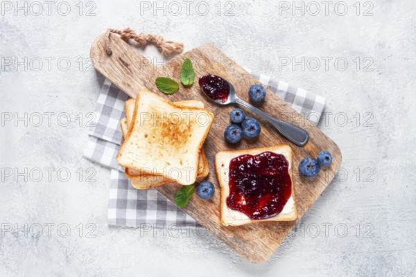 Toast with blueberry jam, on a wooden chopping board, breakfast, homemade, no people