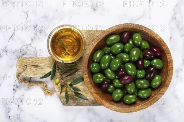 Chalkidiki olives, classic Greek green olives, in a bowl on a cutting board, top view, without people