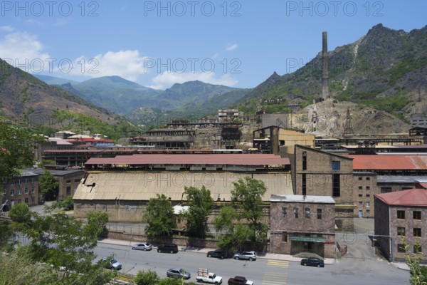 Old industrial complex with chimney in a mountainous area and blue sky, former copper smelter, Alaverdi, Lorikeet province, Armenia