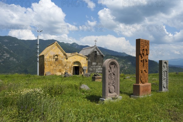 Church with stone sculptures in a green mountain landscape under a cloudy sky, Crossstones, Khachkar, Saint Nshan Church on Debed Gorge, Lorikeet Province, Armenia