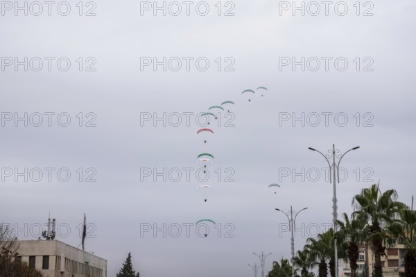 Damascus, Syria â€“ December 08, 2025: Paragliders display the Syrian flag during the first anniversary of the fall of Bashar al-Assad's regime, as hundreds of thousands gather in Umayyad Square to celebrate the historic moment, Damascus, Damascus, Syria