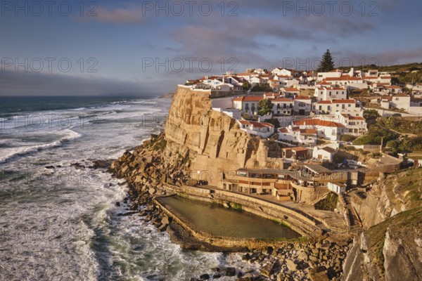 Scenic view of the seaside Azenhas do Mar fishing village on cliff on Atlantic ocean coast, Portugal on sunset