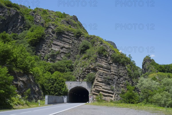 A tunnel in a rocky, green landscape under a clear blue sky, road tunnel, Debed gorge, Lorikeet province, Armenia
