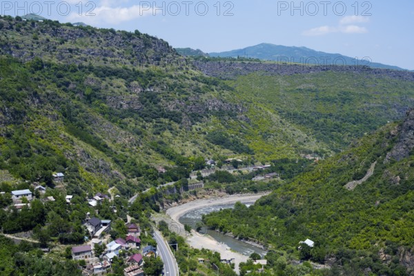 A valley with a river surrounded by wooded mountains and scattered houses under blue skies, views of Sanahin, Debed River, Debed Gorge, Lorikeet Province, Armenia