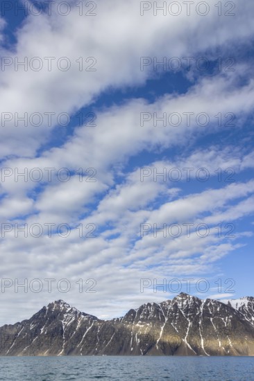 White clouds over mountains along Lilliehöökfjorden, fjord branch of Krossfjorden in Albert I Land, Spitsbergen / Svalbard, Norway