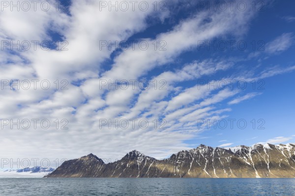 White clouds over mountains along Lilliehöökfjorden, fjord branch of Krossfjorden in Albert I Land, Spitsbergen / Svalbard, Norway
