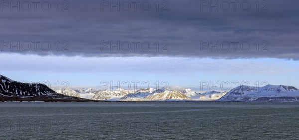 Snow covered mountains and glaciers debouching into Lilliehöökfjorden, fjord branch of Krossfjorden in Albert I Land, Spitsbergen / Svalbard, Norway