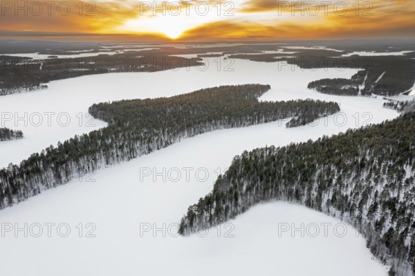 Aerial view over forest and snow covered frozen LahnaselkÃ¤ lake in Kuusamo in winter, Koillismaa, Northern Ostrobothnia region, Finland, Scandinavia