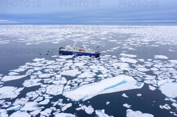 Aerial view over cruise ship Ocean Diamond from Iceland Pro Cruises sailing among drift ice / brash ice in the Arctic Ocean at Svalbard / Spitsbergen