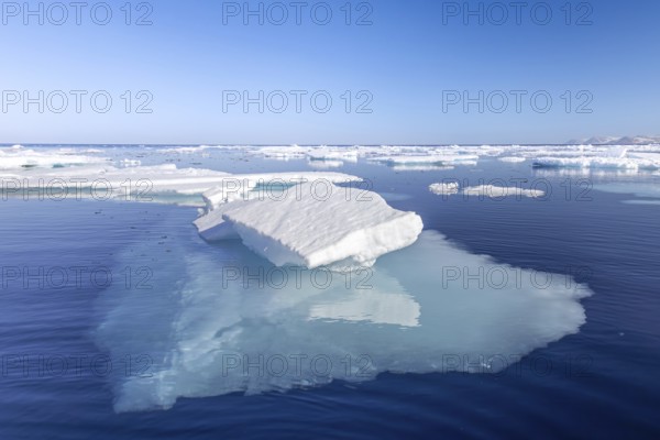 Ice floe among drift ice showing underwater much larger underside in clear sea water of the Arctic Ocean, Spitsbergen / Svalbard, Norway