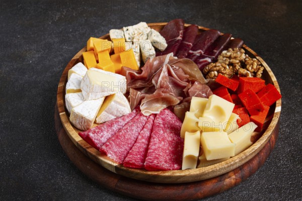Assortment of cheese meat cuts, on a plate, top view, no people