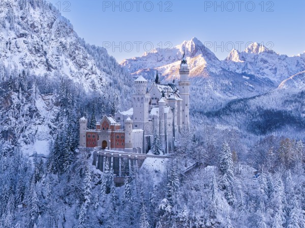 Neuschwanstein Castle nestled in snow, surrounded by snow-covered mountains and forests. Fairytale winter landscape, Schwangau near FÃ¼ssen, OstallgÃ¤u, AllgÃ¤u, Bavaria, Germany