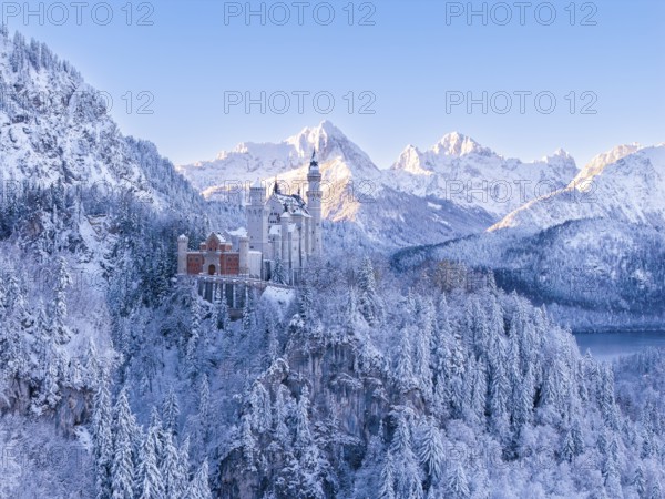 Neuschwanstein Castle rises majestically in a secluded winter landscape surrounded by mountains and snow, Schwangau near FÃ¼ssen, OstallgÃ¤u, AllgÃ¤u, Bavaria, Germany